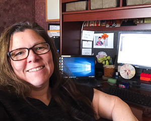 Tonya poses while sitting at her home-office desk.